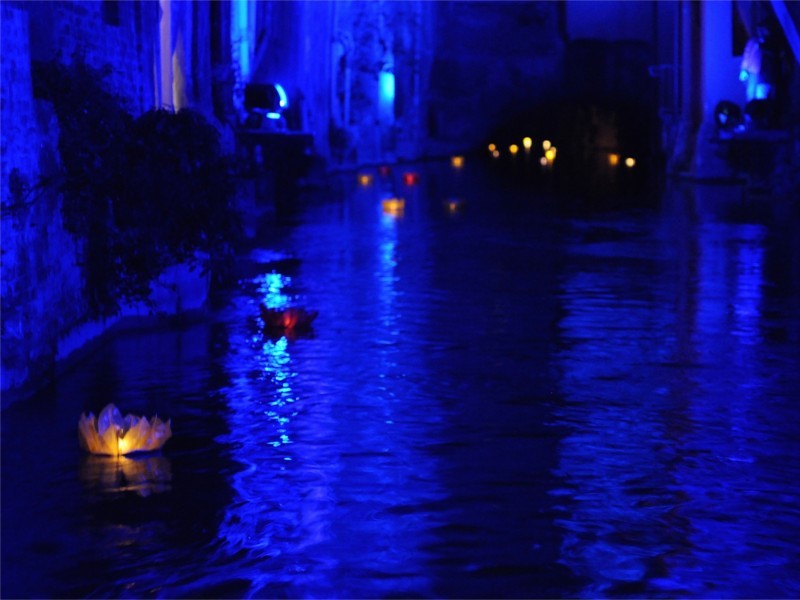 Le lanterne galleggianti luminosi di carta di riso in colori e misure diverse sul fiume canale