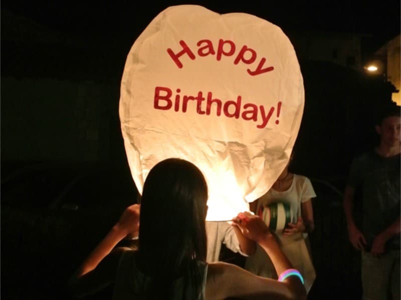 White sky lanterns, hot air balloon shaped for birthday  parties with Happy Birthday printed on the lanterns, fire resistant and biodegradable paper, mounted and strong fuel cell,  ready for use. Open, light it and let if fly!