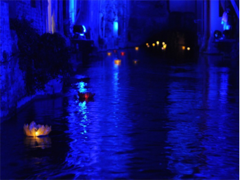 Le lanterne galleggianti luminosi di carta di riso in colori e misure diverse sul fiume canale